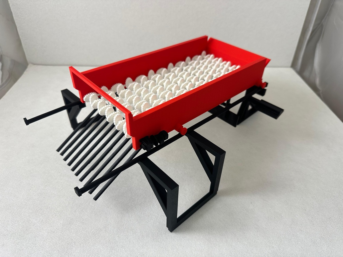Maqueta escala 1:10 de sembradora Treico en rojo y negro con elementos distribuidores blancos